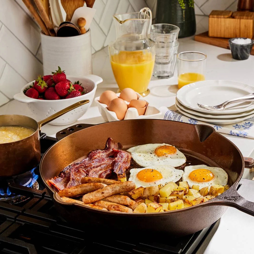 14 inch cast iron skillet on stove with eggs, bacon, sausage and hashbrowns