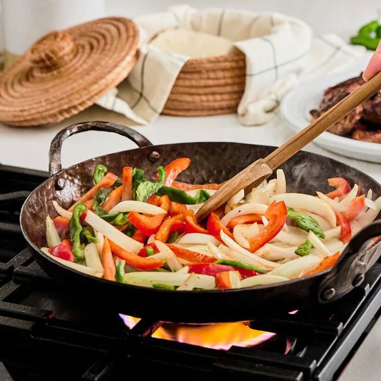 Smithey Ironware Carbon Steel Deep Farmhouse Skillet, 12 inch filled with stir fry vegetables