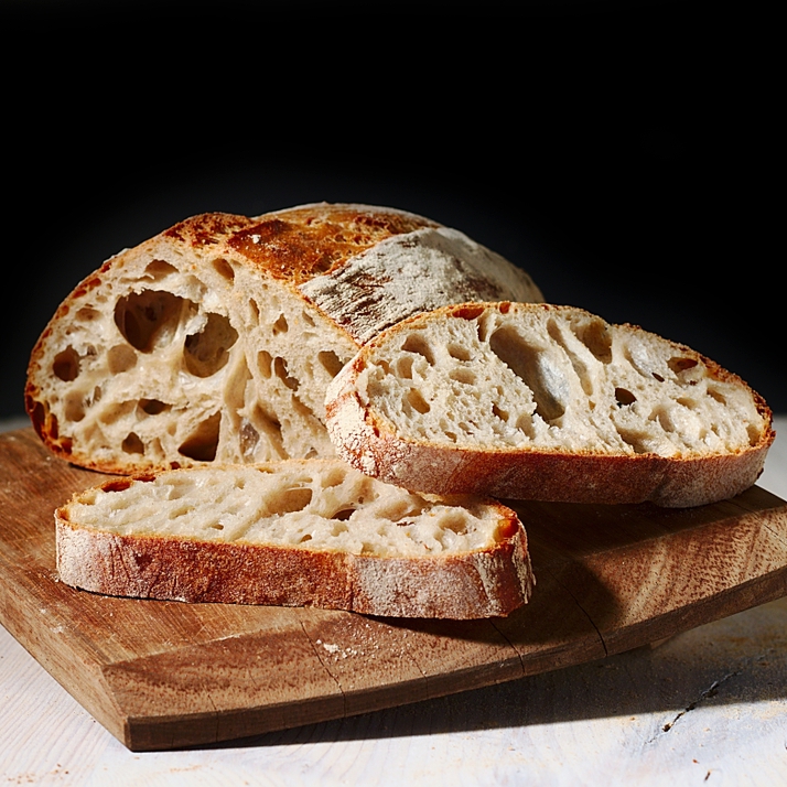 sourdough loaf cut in slices on cutting board