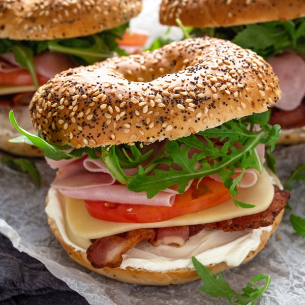 bagel sandwich with lettuce, meat, cheese and tomato