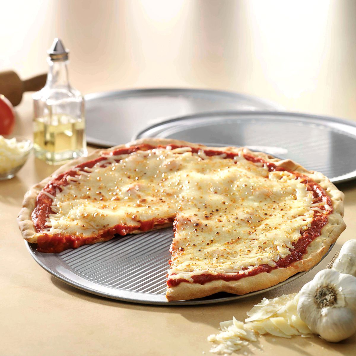 USA Pan pizza pan with cheese pizza baked on it.