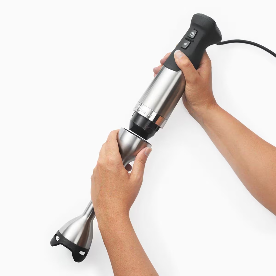 Hands removing the head of the immersion blender