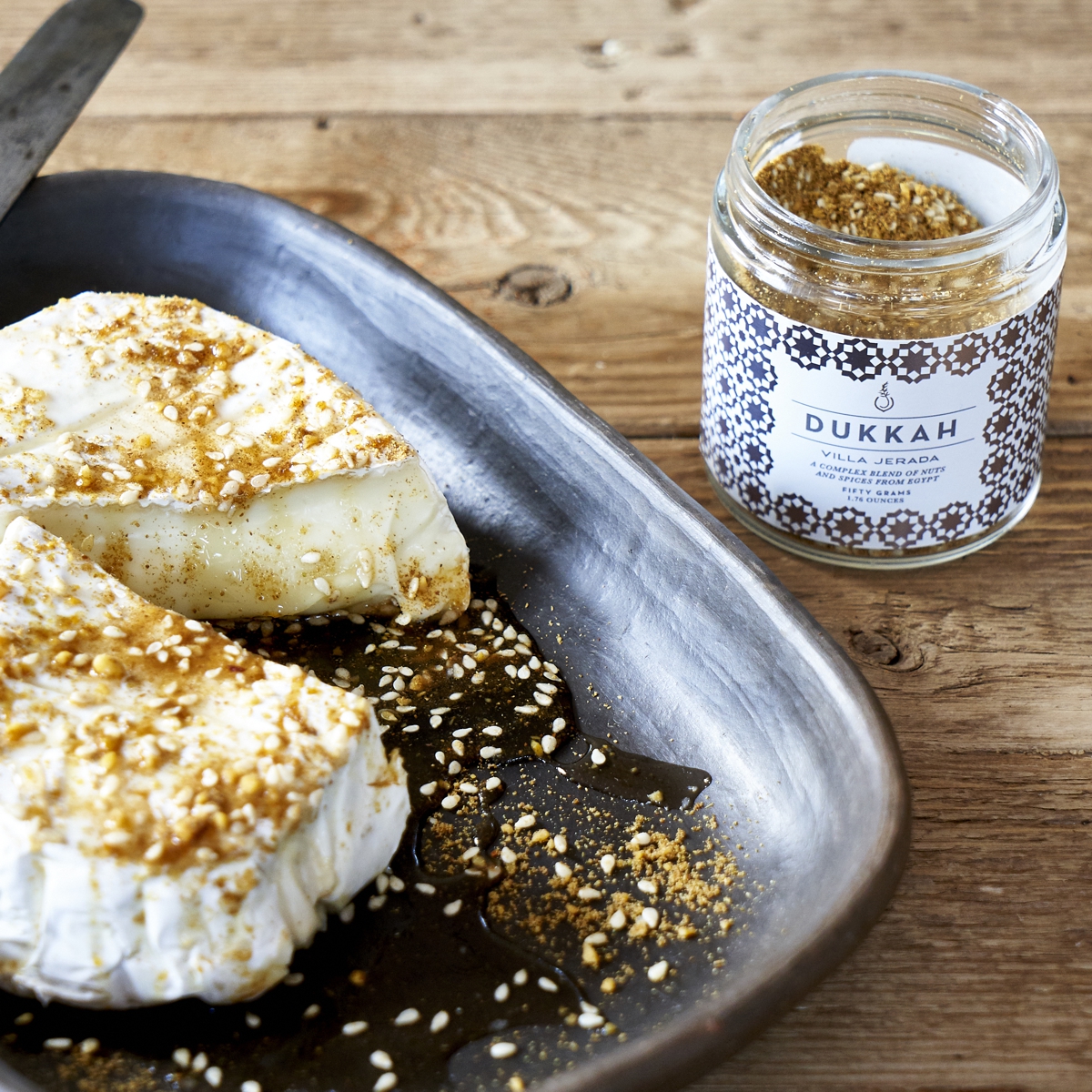 Jar of Villa Jerada Dukkah next to a plate of seasoned food