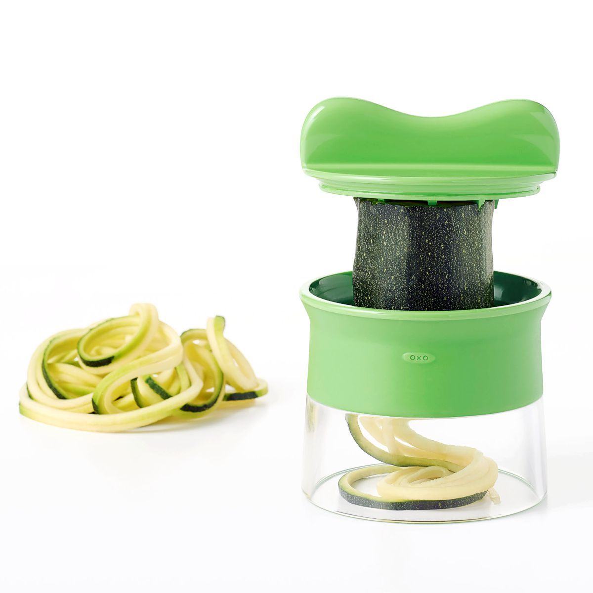 OXO Good Grips hand held spiralizer slicing a cucumber with handle twister.