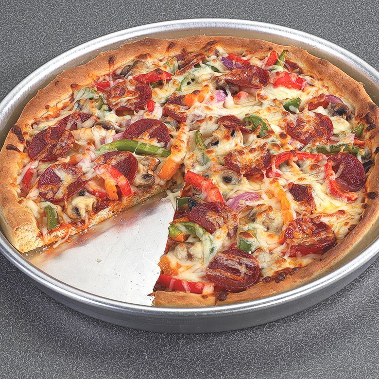 Nordic Ware deep dish pizza pan with pizza inside.