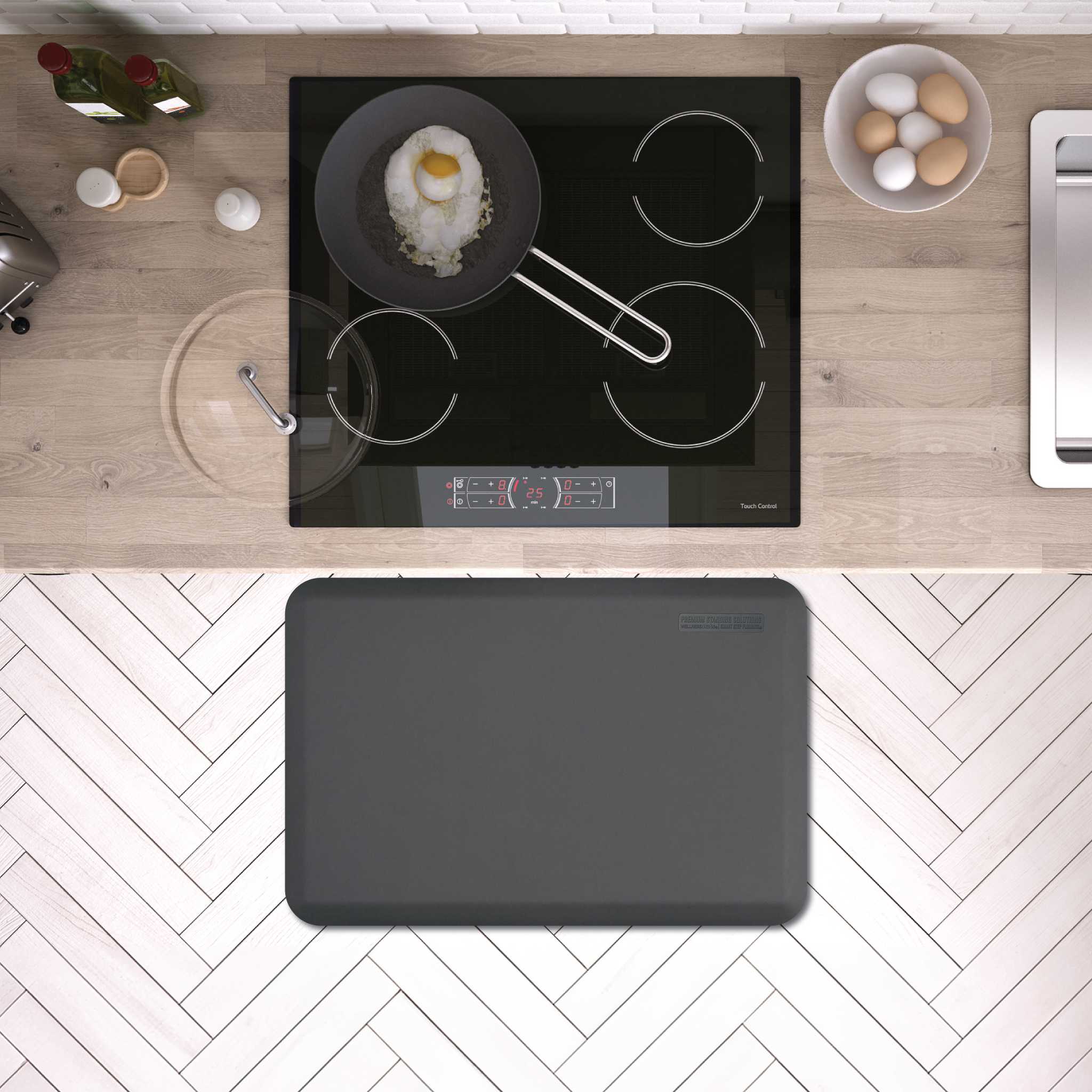 gray wellness mat shown on white herringbone tile in front of stove range top