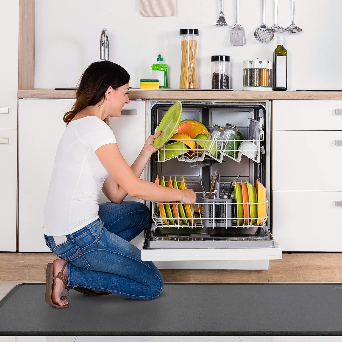 Original wellness mat shown with women kneeling to unload dishwasher