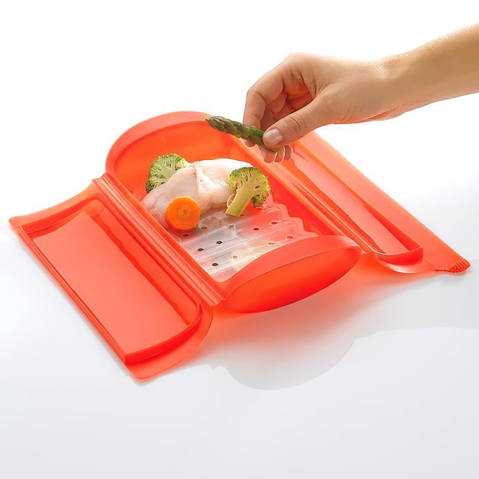 Lekue steam case and tray for two open with steamed food inside.