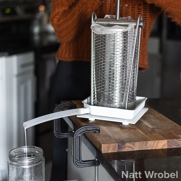 Tabletop fruit press with plastic juice pan