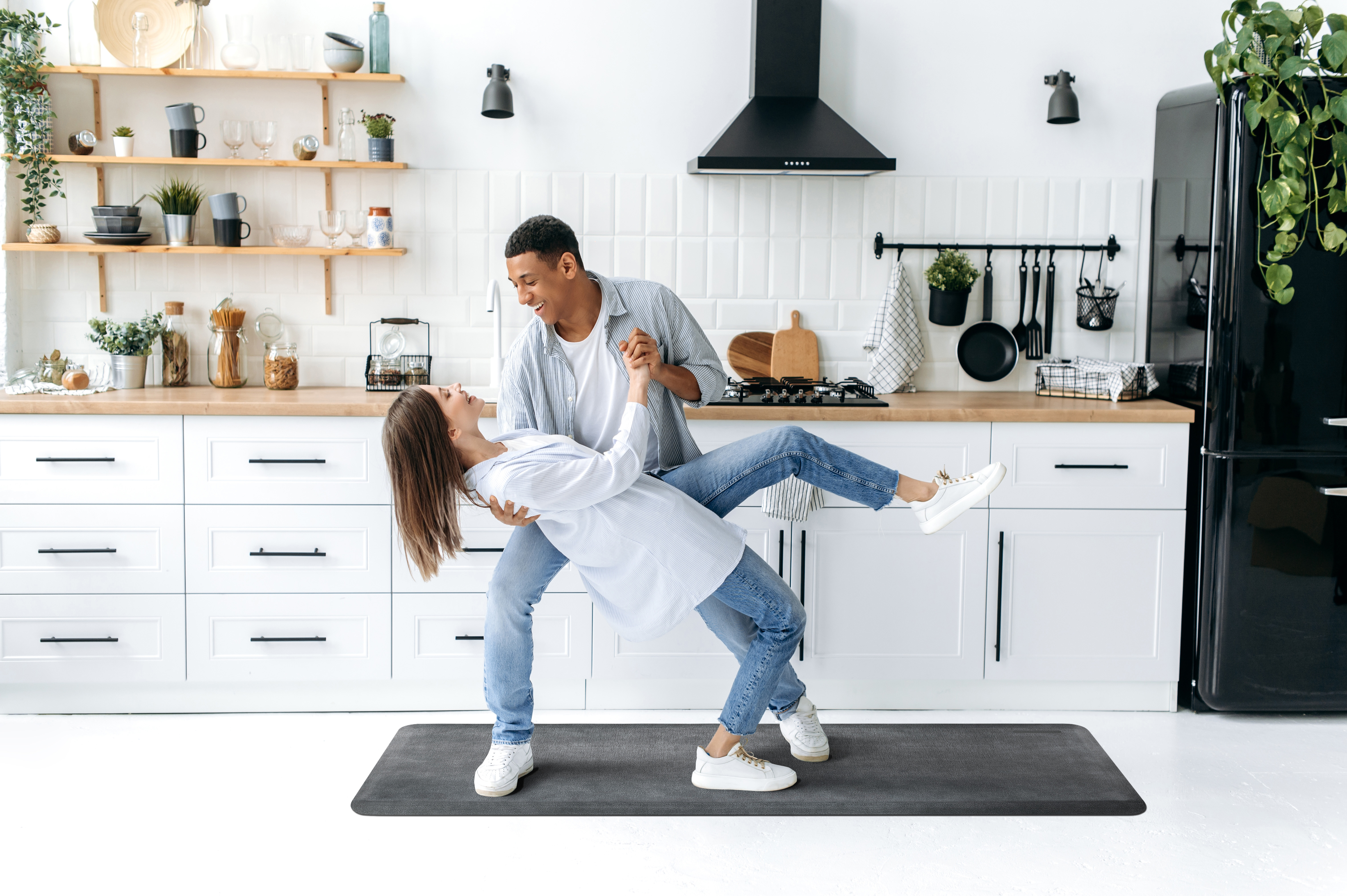 man and women dancing in kitchen on runner wellness mat