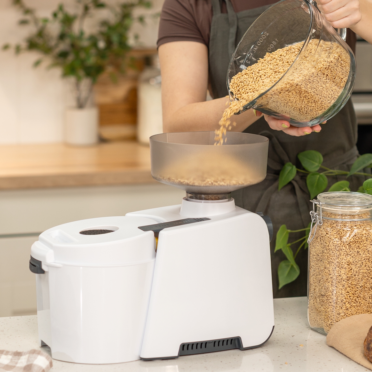 nutrimill impact grain mill with grain being poured in