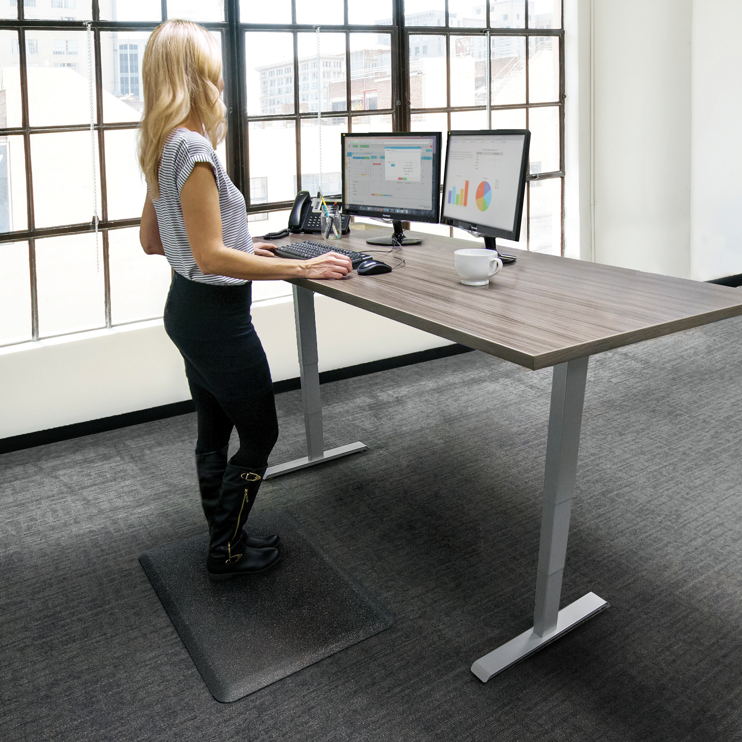 wellness mat shown in front of stand up desk with women standing on it